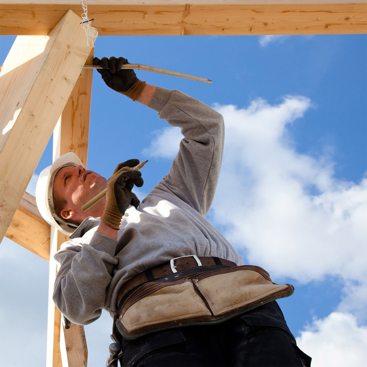 Builder Working On Timber Frame